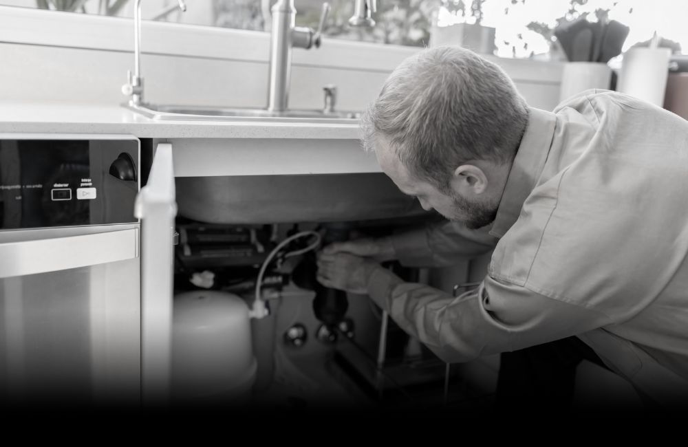 Professional handyman and contractor performing kitchen sink repair in Oakville, Burlington & Mississauga