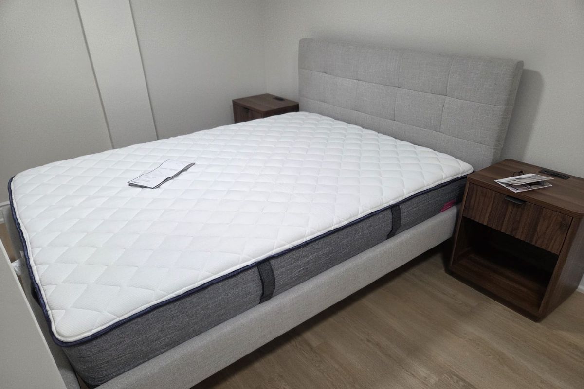Fully assembled upholstered platform bed frame and matching wooden nightstands in an Oakville bedroom by Bespoke Handyman