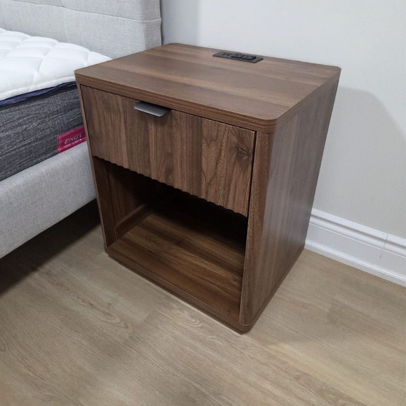 Close-up view of a precision-assembled modern walnut nightstand with built-in power outlets installed in Oakville